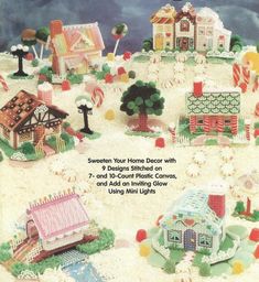 the front cover of a cross stitch book with houses and candy canes on it