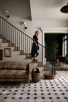 a woman is walking down the stairs in her home