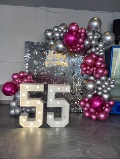 the number fifty five is displayed in front of balloons and a sign that says 50th