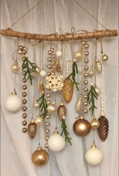 a bunch of ornaments hanging from a wooden stick on a curtain with white drapes