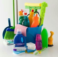 various cleaning products are arranged in a bucket on a white surface, including toothbrushes, gloves and sponges