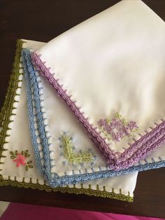 three embroidered napkins on top of each other