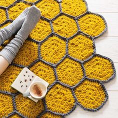 a woman is laying on the floor with her feet up next to a cup of coffee