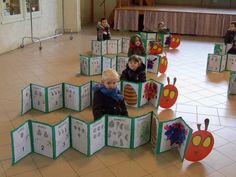 children are sitting on the floor in front of cut out cards with numbers and shapes