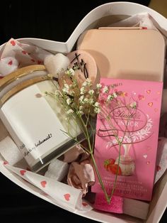 an open heart shaped gift box with flowers and personal care items