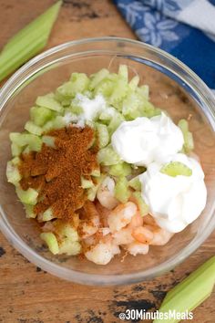 celery, sour cream and other ingredients in a glass bowl on a wooden table