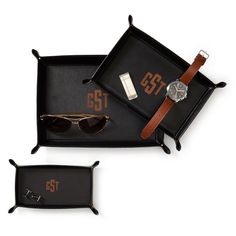 two pairs of sunglasses and a watch in a black tray with brown leather straps on it