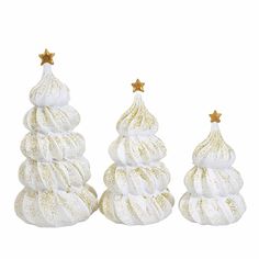 three small white christmas trees with gold stars on the top and one in the middle