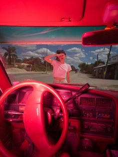 the inside of a car with a red dash light and steering wheel in front of it