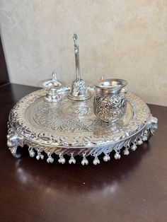 an ornate silver tray with two candles on it