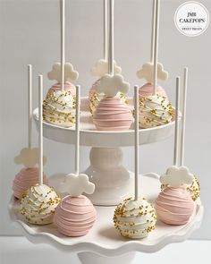 cake pops with gold sprinkles and white frosting are on a plate