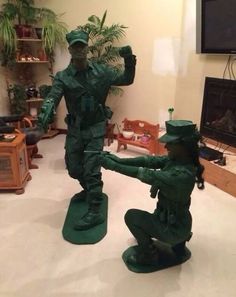 a statue of two men in green uniforms standing next to each other on top of a white floor