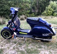 a blue scooter is parked in the grass