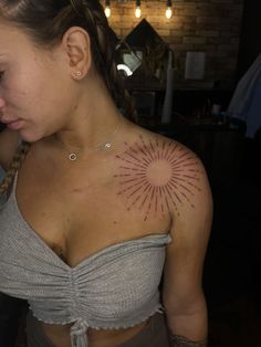 a woman with a sun tattoo on her chest