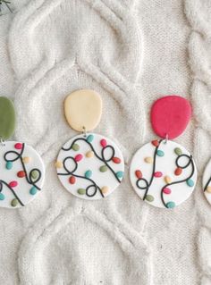 three decorated cookies sitting on top of a white blanket