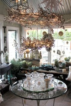 a room filled with lots of glass furniture and decor on top of a metal table