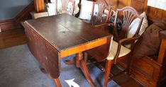 an old wooden table and chairs in a room