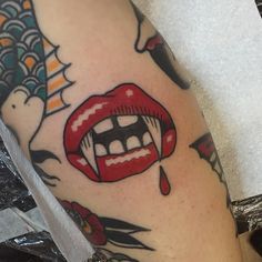 a close up of a person's leg with tattoos on it and a red lip