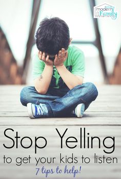 a young boy sitting on the ground with his hands to his face while holding his head