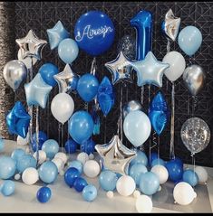 blue and white balloons are arranged on the table