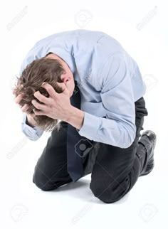 a man kneeling down with his head in his hands