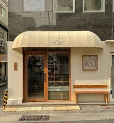 a store front with two wooden benches on the sidewalk