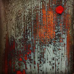 an abstract painting with red circles on the paint and rusted wood grains that is peeling