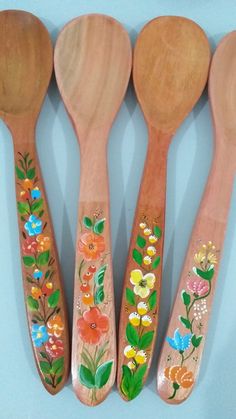 four wooden spoons with painted flowers on them