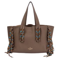 100% authentic Valentino C-Rockee fringe tote in grained olive drab calfskin embellished with signature pyramid studs in copper metal and turquoise cabochon stones. Lined in olive drab suede with two big zipper pockets. Has been carried and is in excellent condition. Measurements Height 26cm (10.1in) Width 34cm (13.3in) Depth 17cm (6.6in) Drop of the Handle 24cm (9.4in) Hardware Copper Metal All our listings include only the listed item unless otherwise specified in the description above. Luxury Top Handle Shoulder Bag With Fringe, Luxury Fringe Rectangular Bag, Luxury Fringe Tote Shoulder Bag, Luxury Fringe Shoulder Bag, Luxury Travel Shoulder Bag With Fringe, Luxury Fringe Shoulder Bag For Travel, Luxury Fringe Bag For Shopping, Luxury Travel Bag With Fringe, Balenciaga Purse