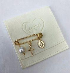 Our 24K gold plated baby safety pin has 3 charms: a gold plated cross, a gold plated virgin (milagrosa), and a natural pearl. It makes the perfect baby shower, new born, and christening gift. You will receive your safety pin in this beautiful pouch to store and carry it safetly. For safety reasons please do not leave the baby unattended while wearing the pin. If you want to choose your own charms please write to me. Gold Safety Pin Jewelry For Wedding, Handmade Gold Jewelry For Baptism, Gift Safety Pin Brooch Jewelry, Gold Safety Pin Shaped Brooch, Gold Safety Pin Shaped Jewelry With Charms, Gold Safety Pin Shaped Brooch Jewelry, Personalized Gold Pins For Gifts, Perfect Baby Shower, Gold Baby