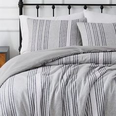 a bed with grey and white striped comforter