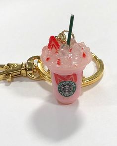 a starbucks drink keychain is shown on a white surface