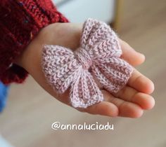 a hand holding a small crocheted bow on it's thumbnails