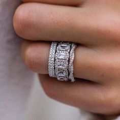 a woman's hand with three diamond rings on her left and the middle finger