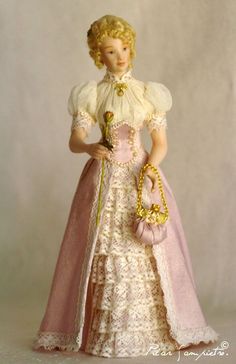 a figurine of a woman in a pink and white dress holding a purse