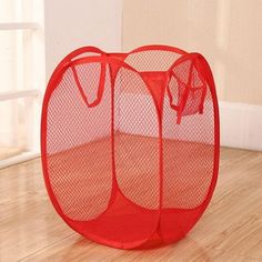 two red mesh storage baskets sitting on top of a hard wood floor