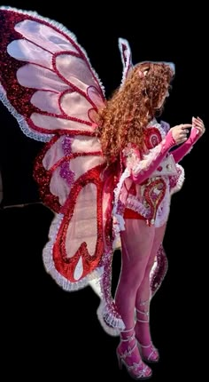 a woman dressed as a fairy holding a cell phone