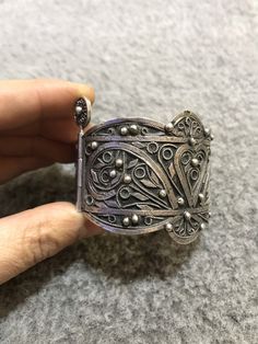 A beautiful antique Algerian silver bracelet with Morocco silver marks, silver filigree, with a sliding pin closure. Handmade from 80 percent silver. The filigree is in good condition and the bracelet functions as it should. It is in general in good vintage condition. Width of large side : 5cm Width of small side : 2,8 cm Inner diameter : 5,9cm Weight : 67,9g Handmade Ornate Cuff Bracelet, Traditional Adjustable Filigree Bracelets, Adjustable Traditional Filigree Bracelets, Bohemian Filigree Cuff Bracelet, Antique Silver Bracelet With Intricate Design, Ceremonial Silver Filigree Ring With Intricate Design, Traditional Filigree Cuff Bracelet Bangle, Ornate Handmade Antique Silver Bracelet, Ornate Sterling Silver Filigree Cuff Bracelet