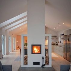 a living room filled with furniture and a fire place in the middle of it's wall