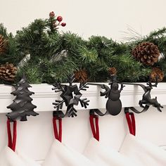 christmas stockings hanging on a mantle with pine cones