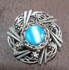 Very pretty vintage dress brooch. It has a striking turquoise glass, blue cabochon at its centre and the metal around it has little floral detailing. Has a celtic look about it.   It will look fabulous on a scarf, coat or evening dress.  3.5cm dia x 2 cm deep.  Price includes tracked shipping. Blue Cabochon Brooches For Wedding, Dress Brooch, Scarf Coat, Wedding Brooches, Brooch Dress, Wedding Brooch, Turquoise Glass, Vintage Dress, Beautiful Dress