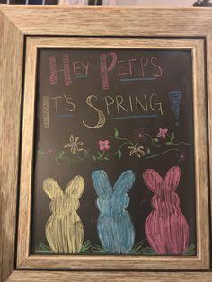 a chalkboard sign with three rabbits painted on it and the words hey pees it's spring