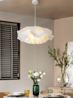 a dining room table with plates and vases on it