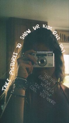 a woman taking a selfie in front of a mirror with words written on it