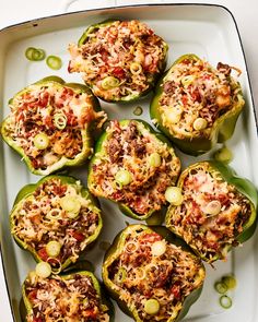 several stuffed peppers with toppings on a white tray