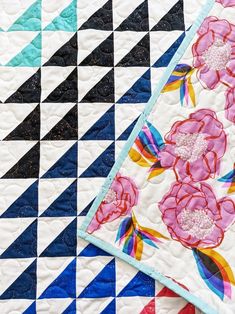 two quilts with flowers on them sitting next to each other