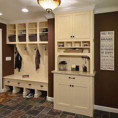 a walk in closet filled with lots of white cabinets