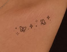 the back of a woman's chest with three butterflies and stars tattoo on it