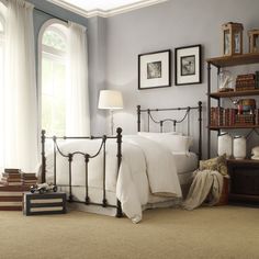 a bed room with a neatly made bed and two framed pictures on the wall above it