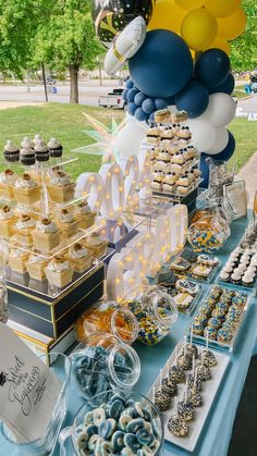 a table topped with lots of desserts and balloons